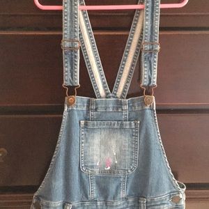 Cute girls paint splattered overalls